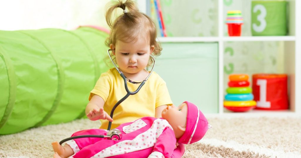 Djevojčica sa stetoskopom 
se igra doktora s bebom-lutkom
