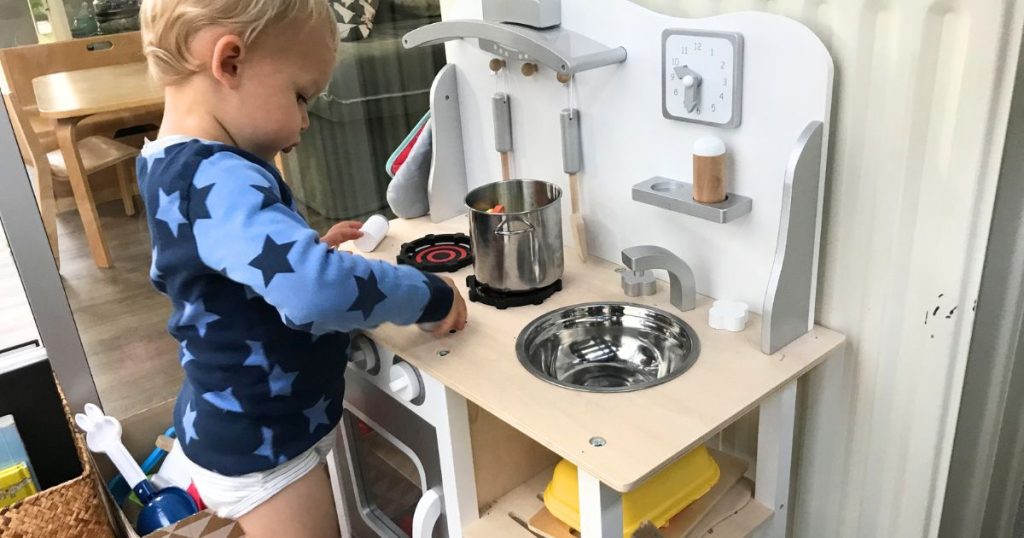 Igra uloga kao prirodan poticaj za govor - Dječak u dječjoj kuhinji priprema obrok
